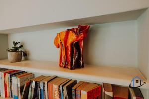 a vase sitting on a shelf with books at Unique Boathouse, detached free parking x4 cars in Kingston upon Thames