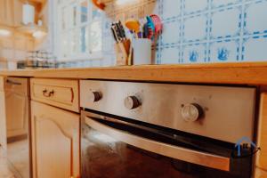 a kitchen with a stove with a wooden counter top at Unique Boathouse, detached free parking x4 cars in Kingston upon Thames