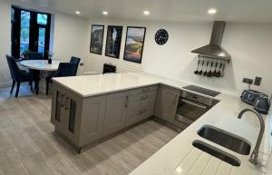 a kitchen with a counter and a table with a stove at Modern Coastal Cottage in Killybegs