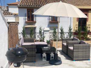 a grill and an umbrella on a patio at Apartamento Socorro in Ronda