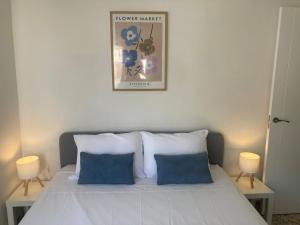 a bedroom with a white bed with two blue pillows at Apartamento Socorro in Ronda