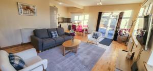 a living room with a couch and a table at Stobhill 2 Bedroom House with sofa bed OR Stobhill 2 Bedroom Apartment - Gorebridge in Gorebridge