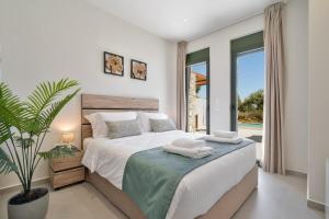 a bedroom with a bed and a large window at Villa Meraki in Stalos +27 photos