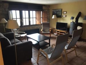 ein Wohnzimmer mit Sofa, Stühlen und einem Tisch in der Unterkunft La Busta in Villaviciosa