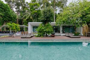 a swimming pool with chairs and a house at KPG Suite Dream in Ban Nua