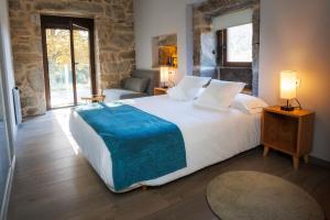 a bedroom with a large white bed with a blue blanket at Casa Yañez • XuresVillas in Bubaces