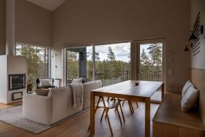 a living room with a table and a couch at Hilltop House Premium Forest Villa in Inkoo