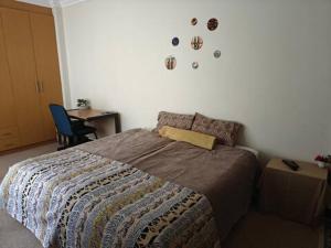a bedroom with a bed and a desk and a table at 7 on school - Cozy guesthouse 15 min drive from airport and close to major highways in Germiston