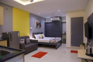 Un dormitorio con una cama, un sofá y un televisor. en Srinivasam-StudioFlat13-Kondapur, en Lingampalli