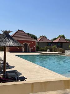 a swimming pool with chairs and an umbrella at Appartement 2 chambres in Prayssac