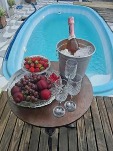 a table with wine glasses and a bucket of fruit at Pousada Vida & Brisa in Pelotas