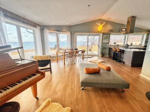 a living room with a piano and a dining room at Grannen Lodge in Storheil