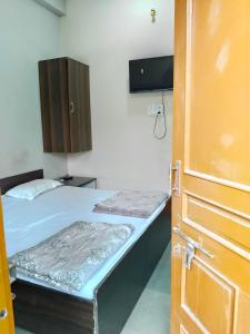 Habitación con 2 camas, armario y puerta en Rudra Homes, en Ujjain