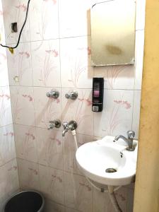 un baño con lavabo y espejo en Rudra Homes, en Ujjain