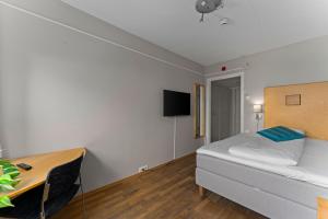 a bedroom with a bed and a desk and a table at Dølaheimen in Lillehammer
