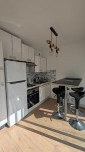 Una cocina con una mesa y dos taburetes en ella. en T1 bis avec parking à 10 min à pied du centre, en Vannes