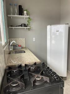 a kitchen with a stove and a white refrigerator at Apto no centro de Belém Nos altos in Belém +9 photos
