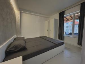 a bed in a room with a large window at Seagull Apartments in Byala