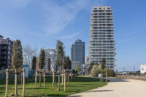 a park with trees in front of a tall building at Central Heaven in Ostend