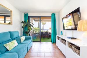 a living room with a blue couch and a tv at Best duplex FREE WIFI in Playa Paraiso