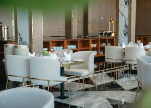 une salle à manger avec des chaises blanches et une table dans l'établissement Gerwill Hotel, à Dodoma