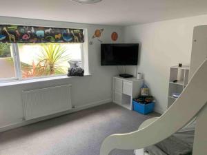 a living room with a flat screen tv and a window at Featured on Channel 4 with George Clarke with lazy spa in Bournemouth