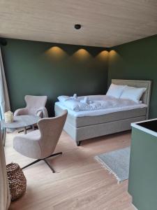 a bedroom with a bed and a chair at Hytte Blåtind, Rekkedal Gjestegard - Sæbø in Sæbø +10 photos