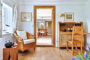 a living room with a mirror and a chair and a table at Reetkate in der Natur in Hasselberg