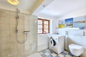 a bathroom with a washing machine and a shower at Reetkate in der Natur in Hasselberg +11 photos