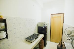 a kitchen with a stove and a refrigerator at Phagun Suites Homestay in Dibrugarh