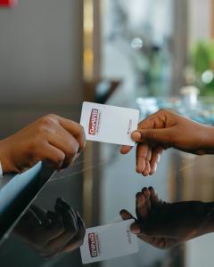 une personne remettant une carte professionnelle à une autre personne dans l'établissement Gerwill Hotel, à Dodoma