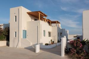 a white house with a wooden roof at Malvia Beach House Naxos in Kastraki