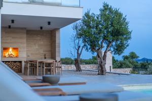 eine Terrasse mit einem Tisch, Stühlen und einem Kamin in der Unterkunft Villa Belvedere 1 ZadarVillas in Sveti Filip i Jakov + 31 Fotos