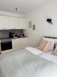 a white kitchen with a large bed in a room at Ferienwohnung Bächle, sehr zentral in Freiburg im Breisgau