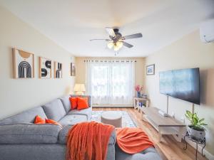 CornwallTranquil Riverside Abode的客厅配有灰色沙发和平面电视