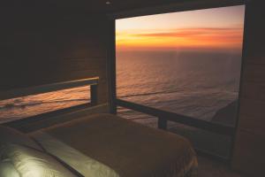 a bed in a room with a view of the ocean at Cabañas Mirador de Matanzas in Matanzas