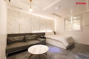 a living room with a couch and a bed at S Hotel in Bucheon