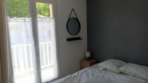 a bedroom with a bed and a mirror and a window at Résidence LA CROISIERE in Anglet +9 photos