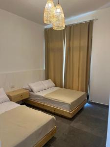 a bedroom with two beds and a chandelier at Caesar Sodic in Ras Elhekma
