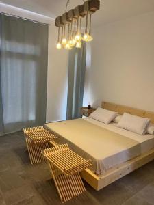 a bedroom with a bed with two chairs and a chandelier at Caesar Sodic in Ras Elhekma