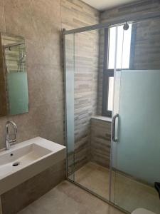 a bathroom with a sink and a glass shower at Caesar Sodic in Ras Elhekma