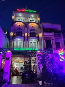 a building with a neon sign on the front of it at Nhà nghỉ Hoa Ngọc Lan Biên Hòa in Bùi Tiếng