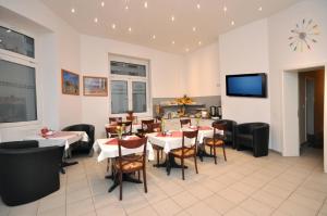 a restaurant with tables and chairs and a flat screen tv at Hotel Apadana Frankfurt in Frankfurt