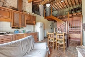 a kitchen with a table and a white refrigerator at Villa Chelucci - Gualdo in Massarosa