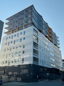 a tall white building with a lot of windows at Pramea Apartments Aallonharja 5 in Jyväskylä