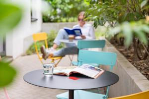 a man sitting at a table reading a book at STAYERY Berlin Friedrichshain - stylish Rooms & Apartments in Berlin