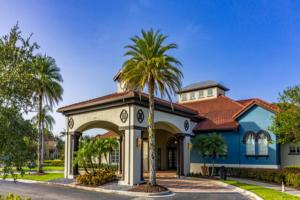 a house with a palm tree in front of it at The Hearth Home - 4 Suites in Kissimmee