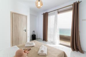 a bedroom with a bed and a large window with the ocean at Villa Claire in Andiskárion +49 photos