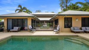 una casa con piscina di fronte a una casa di The Pavilion at Trinity Beach a Trinity Beach