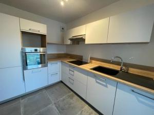 a kitchen with white cabinets and a sink at Quiberon - Grand T2 - Balcon Sud - 70m² - Plage & Centre - Parking & WIFI - FR-1-478-203 in Quiberon